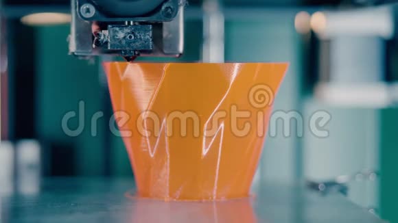 3D打印机正在生产一个橙色花瓶在3d打印实验室工作的3d打印机视频的预览图