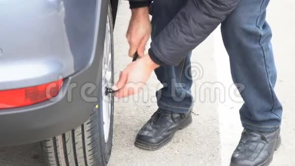 男人拧紧汽车轮子上的螺母检查车轮螺母的拧紧情况视频的预览图
