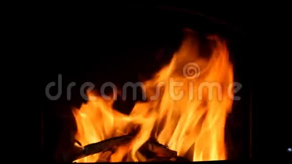 橙色的火焰在黑暗的壁炉里燃烧闪烁着火花视频的预览图