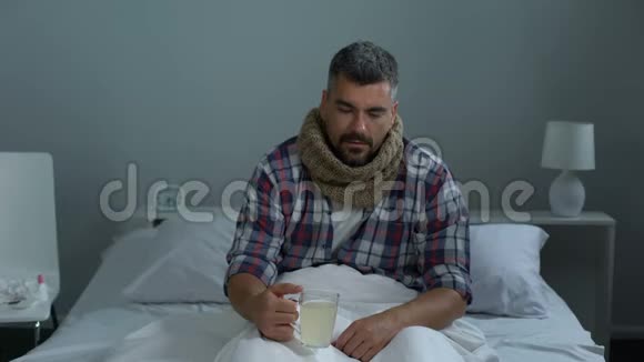 病人在床上咳嗽喝解热茶治疗发烧流感流行视频的预览图