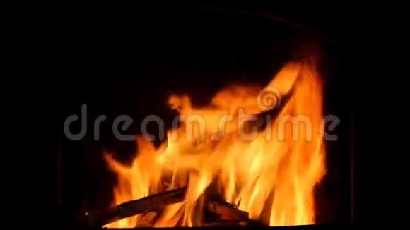 橙色的火焰在黑暗的壁炉里燃烧闪烁着火花视频的预览图