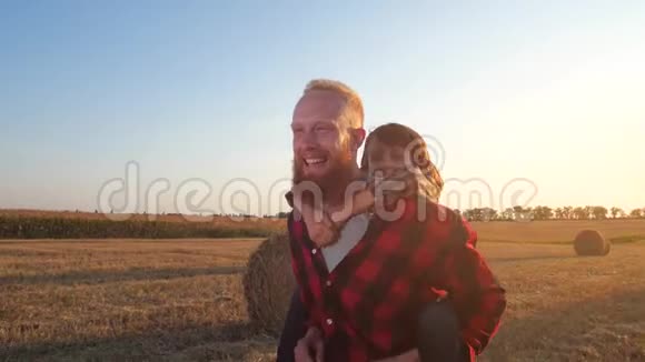 快乐的爸爸载着儿子在田野里奔跑视频的预览图