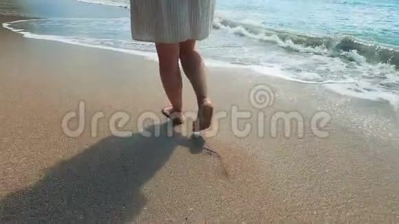桑迪海岸和一个赤脚的女人走着视频的预览图