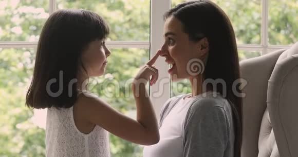 嬉戏的小妈妈和可爱的小女儿在摸鼻子视频的预览图