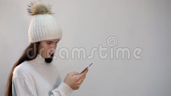戴着白色帽子的少女在电话里发短信视频的预览图