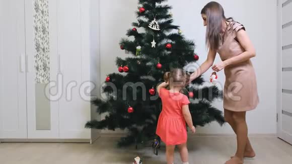 家庭寒假和人的概念幸福的母亲和小女儿在家装饰圣诞树视频的预览图