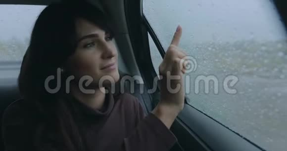 雨天坐在车里的女人把心引到窗上视频的预览图