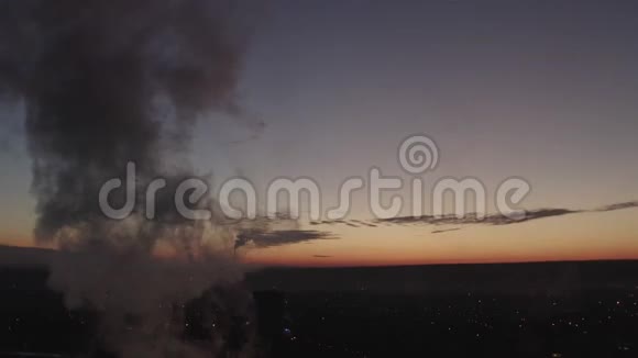 从烟囱里升起的浓烟顶着夕阳晚上城市的主要锅炉房视频的预览图