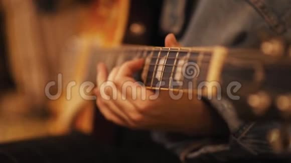 女孩在沙发上弹吉他女人在室内创作音乐这位艺术家用低音吉他演奏音乐家作曲视频的预览图