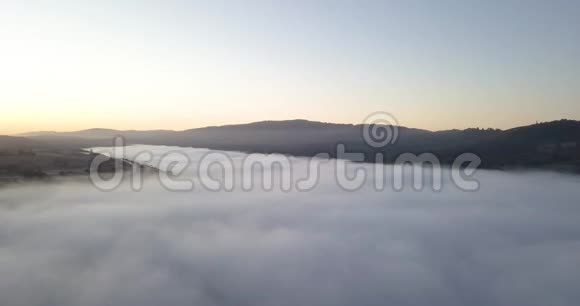日出时雾蒙蒙的山谷弥漫着金色渐变的天空视频的预览图