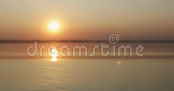 日落时分一只手在大海或湖水中放飞一只纸船的剪影TT视频的预览图