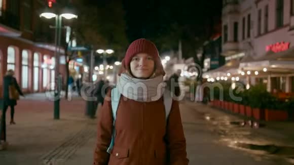 冷夜街上幸福的女人走路和微笑的镜头视频的预览图