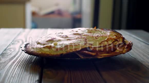 女人把热煎饼从平底锅到盘子站在一张旧木桌上视频的预览图