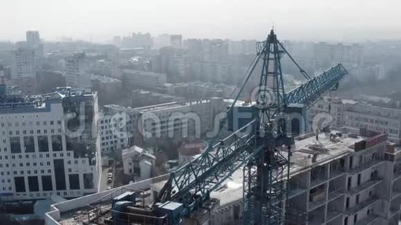 吊车的圆形顶镜头和在冬季建造一座新的多层建筑的过程视频的预览图