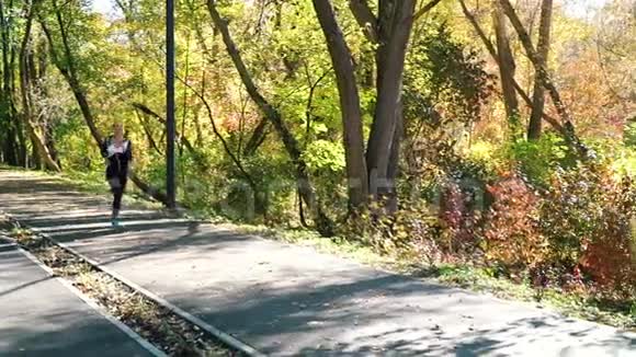 秋天在城市公园慢跑后休息的漂亮女孩视频的预览图