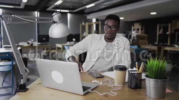年轻的非洲男人正在看录像和微笑视频的预览图