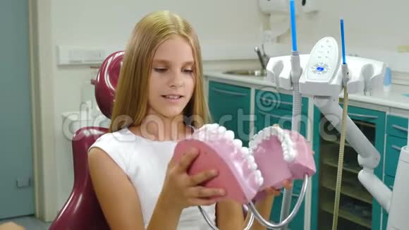 儿童牙科学牙齿保护理念漂亮的10岁女孩手里拿着牙齿模型微笑开朗的病人视频的预览图