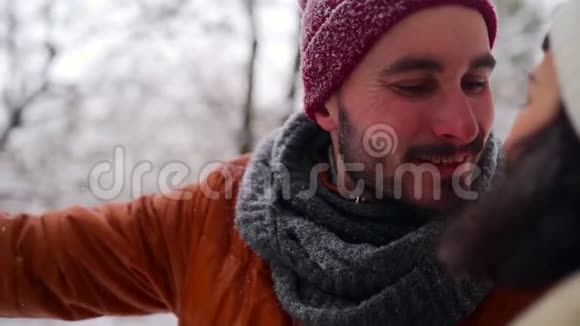 在圣诞节假期的寒假里在户外享受降雪的嬉皮士男子快乐的家伙在雪地里张开双臂视频的预览图