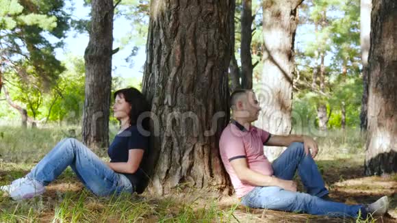 恩爱夫妻或家庭的关系一男一女坐在不同的森林或公园的地上视频的预览图