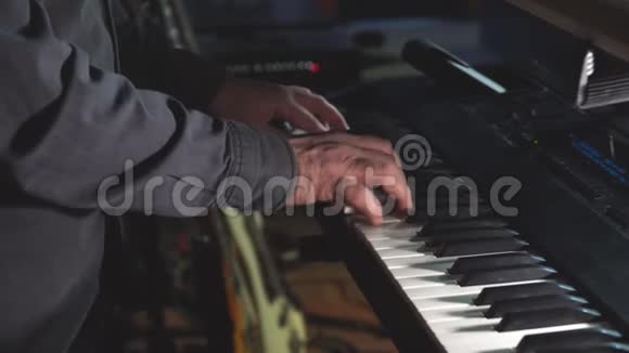 摇滚乐队的钢琴演奏家或键盘演奏家在舞台上站在一个小球或一个俱乐部里演奏合成器视频的预览图