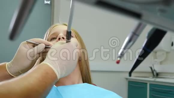 牙科诊所的儿童病人出诊专家牙科治疗概念带着钻头和镜子的牙医视频的预览图