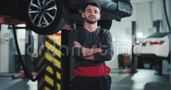 在汽车修理厂一个穿着制服的机械师脸上挂着大大的微笑心情很好直勾勾地看着视频的预览图