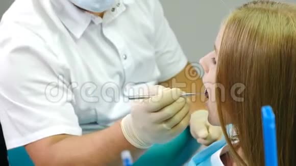 牙医办公室医生用镜子和特殊的牙科工具检查儿童牙齿儿童牙科病人视频的预览图