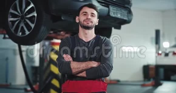 在汽车服务中心一个有魅力的机械师站在镜头前严肃地看着视频的预览图