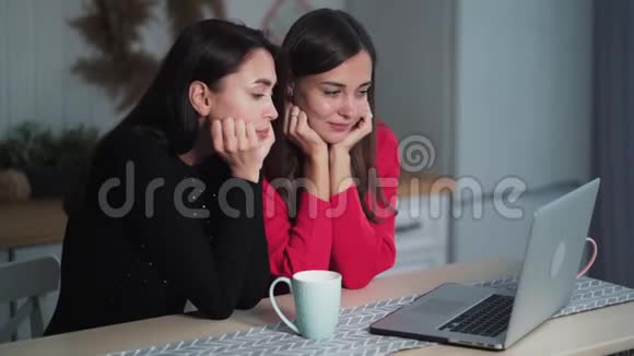 无聊的年轻女性朋友在家里用笔记本电脑看视频讨论这个问题视频的预览图