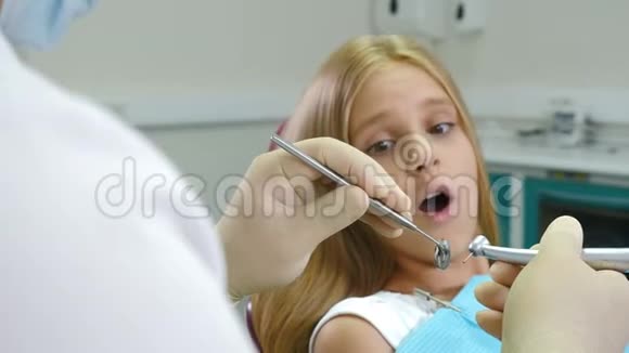 牙医办公室里的小女孩健康和牙科保健牙科医生的特写镜头手里拿着钻头和镜子4K视频的预览图