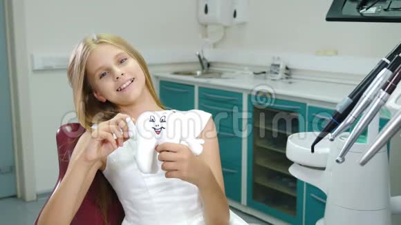 在牙医办公室微笑的孩子小病人看着相机微笑拇指向上可爱的少女视频的预览图