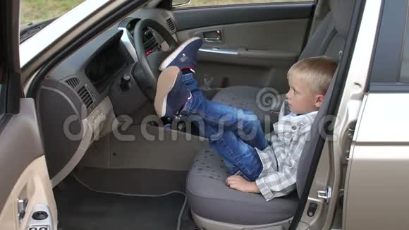 一个小商人坐在车里他把脚踩在方向盘上视频的预览图