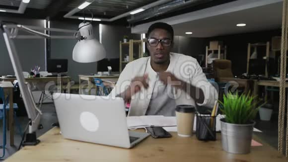 戴眼镜的非洲男人摸着头感到偏头痛人健康和压力的概念视频的预览图