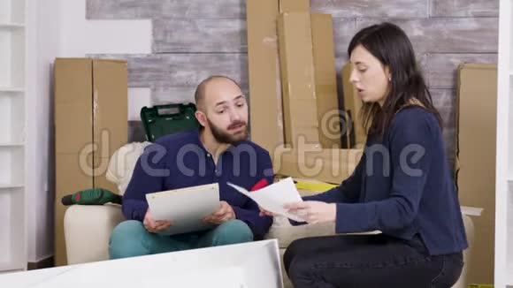一对夫妇读新房子家具装配说明书视频的预览图