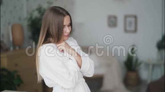 身着白色浴袍的美女在家受凉的肖像冻僵了视频的预览图