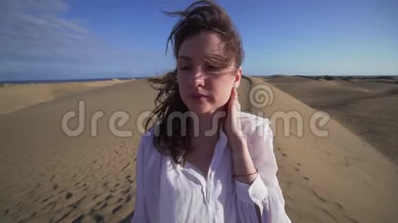 一个年轻的女人站在炎热的沙漠里她的头发在动视频的预览图