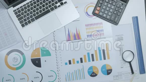 商人在办公桌上工作手提电脑和财务报告上景视频的预览图