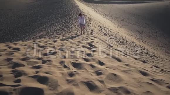 沙漠冒险一个年轻的女人爬上沙丘在炎热的夏天万德拉斯概念美丽的自然视频的预览图