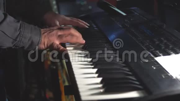 摇滚乐队的钢琴演奏家或键盘演奏家在舞台上站在一个小球或一个俱乐部里演奏合成器视频的预览图