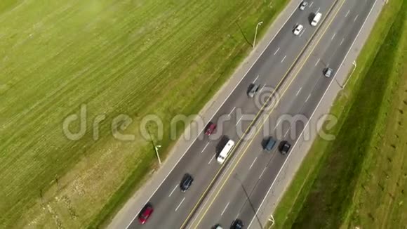 从无人驾驶飞机在沥青路上的空中视野一条被汽车和其他交通工具分隔的公路视频的预览图