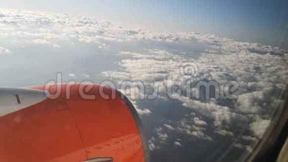 橙色的飞机飞过云层从舷窗可以看到视频的预览图