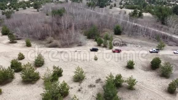 神圣的几辆汽车正沿着一条沙路行驶无人机航拍视频视频的预览图