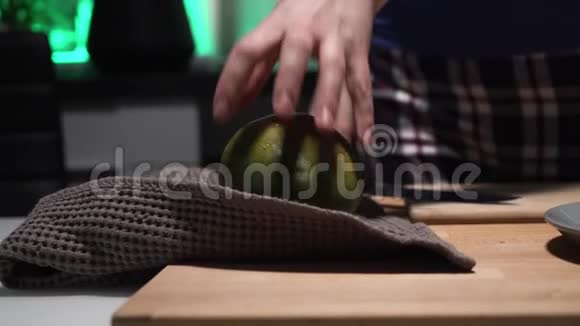 穿格子裤的女孩在厨房的木板上用大刀切芒果视频的预览图
