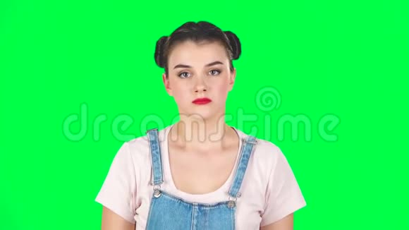 女孩愤怒地捂住耳朵双手放在工作室的绿色屏幕上慢动作视频的预览图