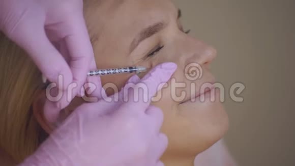 美容医生的特写医生给一个年轻女孩做抗衰老注射动作缓慢美容师做的视频的预览图