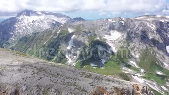 在岩石悬崖冰川和雪峰上拍摄的山脊的空中拍摄令人惊叹的山景视频的预览图