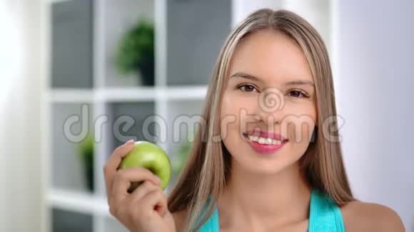妩媚素雅的少女脸上挂着绿色维他命苹果对着镜头微笑视频的预览图