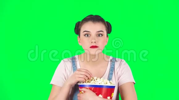 可爱的女孩一边吃爆米花一边看电影带着咒语的女孩看着慢动作视频的预览图