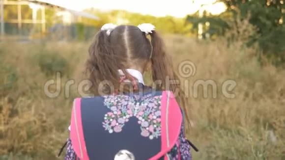 一个7岁的小女孩从学校回来肩上扛着一个公文包后视镜视频的预览图