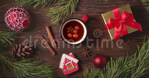 木桌上放着杉树枝的果茶杯和圣诞装饰品视频的预览图